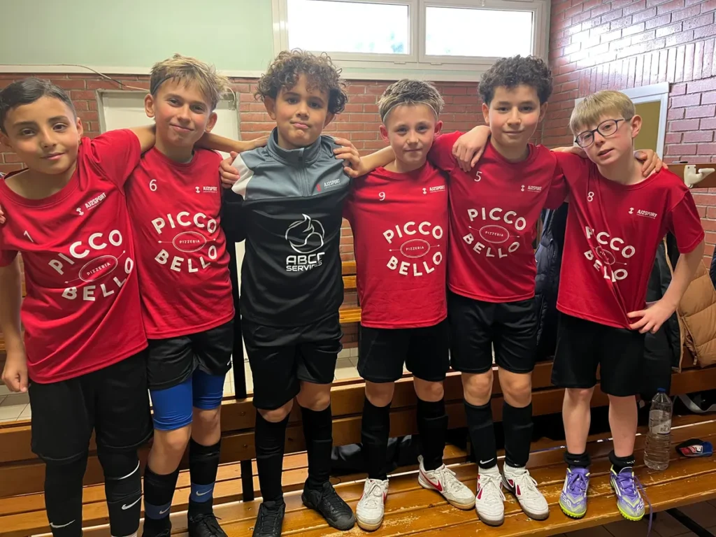 Groupe de jeunes footballeurs posant ensemble après un match
